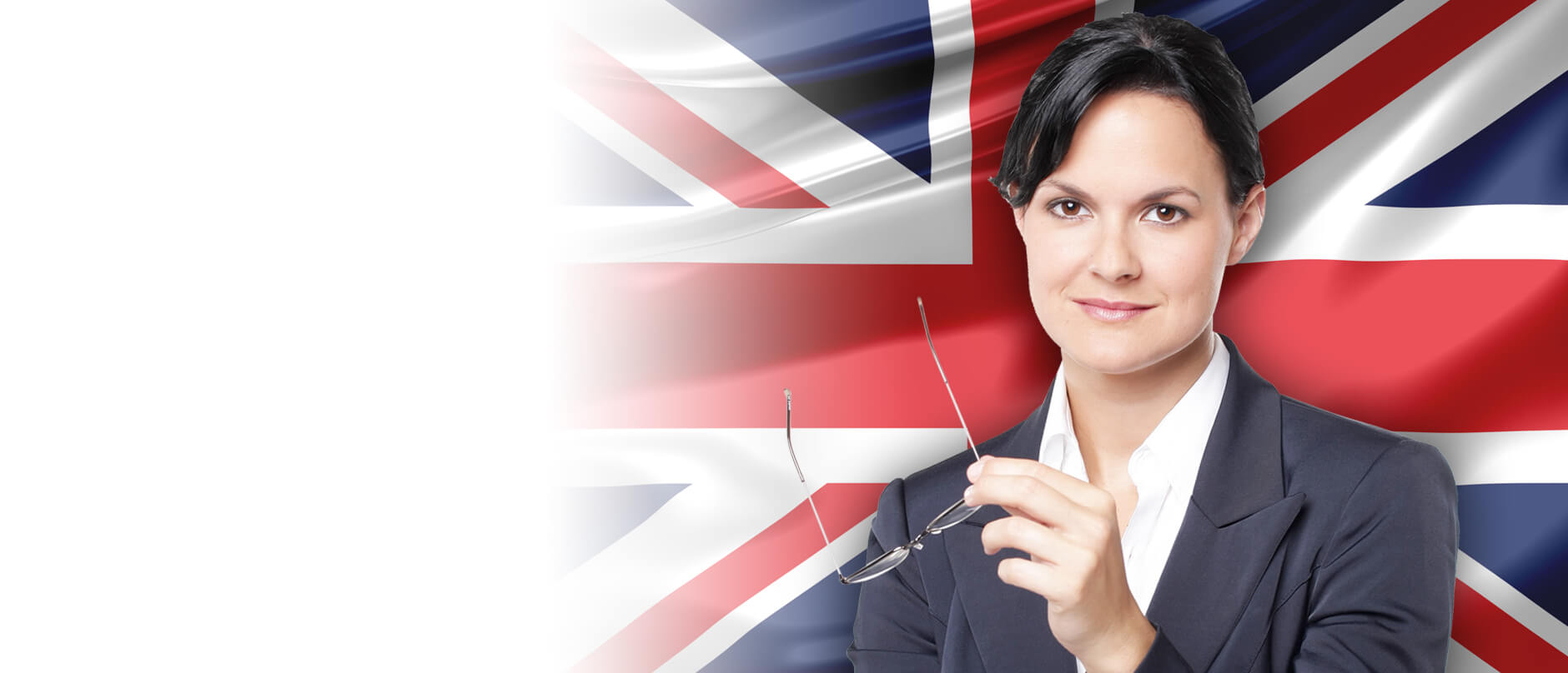 Młoda w żakiecie kobieta uśmiecha się na tle flagi brytyjskiej